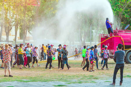 KANCHANABURI, THAILAND - APRIL 17, 2019: Unidentified Thai people in wet clothes fun with fire truck pours water on people from a hose water during Songkran festival at temple on april 17, 2019 in Kanchanaburi, Thailand.のeditorial素材