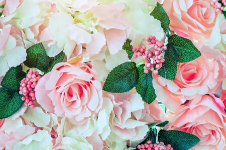 Many artificial pink and white roses are decorated on the glass door to the backdrop in the afternoon. Beautiful flowers background, Selective focus.の写真素材