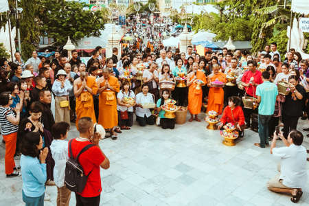 NAKHON PATHOM THAILAND - NOVEMBER 16 :  Unidentified Thai monks bestowed ribbon-flowers on the poor/bystanders as a religious ritual of almsgiving at Wat Phra Pathommachedi on November16,2019 in Nakhon Pathom, Thailandのeditorial素材
