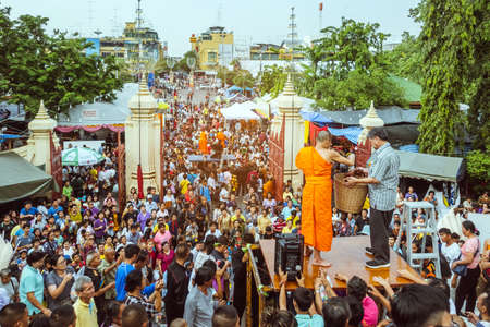 NAKHON PATHOM THAILAND - NOVEMBER 16 :  Unidentified Thai monks bestowed ribbon-flowers on the poor/bystanders as a religious ritual of almsgiving at Wat Phra Pathommachedi on November16,2019 in Nakhon Pathom, Thailandのeditorial素材