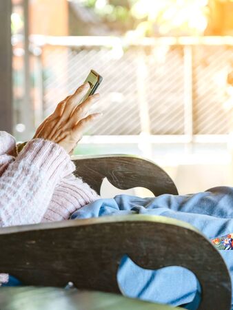 Woman relax and use mobile phones to shop online while at home to stop the spreading of the corona virus (covid-19). Selective focus on mobile phone.の写真素材