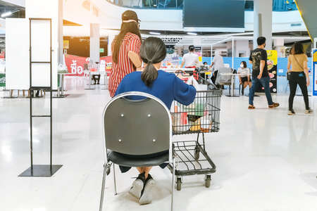 KANCHANABURI/ THAILAND - APRIL 4 2020: Unidentified people order food to take home inside of Robinson closes due to the corona virus (Covid-19) outbreak but opens only food section at Robinson Department Store. Restaurants set chairs for waiting for the fのeditorial素材