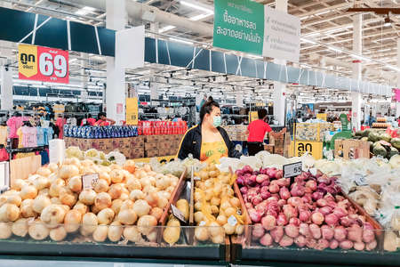 KANCHANABURI, THAILAND - APRIL 12,2020: Unidentified female  customer wearing face protection in prevention for coronavirus(covid -2019) and shopping at Tesco Lotus on April 12,2020 in Kanchanaburi,Thailand.のeditorial素材