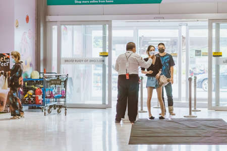 KANCHANABURI, THAILAND - APRIL 6,2020: Unidentified Officer use thermometer scan temperature for fever in people as coronavirus or COVID-19 outbreak at Robinson Department Store on april 6,2020 in Kanchanaburi,Thailand.のeditorial素材