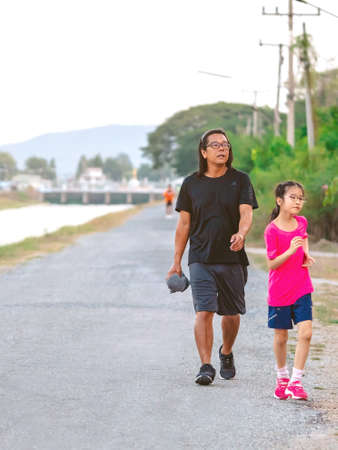 KANCHANABURI/THAILAND-MAY 7,2020 : Unidentified Thai sportive people jogging for good health on road beside irrigation canal at Mae Klong Dam on may 7,2020 in Kanchanaburi, Thailand.のeditorial素材
