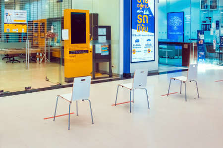 KANCHANABURI THAILAND-MAY 13,2020: Spacing chairs zone to sit and wait for transactions with the bank during the spread of the Corona virus(Covid-19) in front of the bank at Robinson department store.のeditorial素材