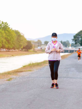 KANCHANABURI/THAILAND-MAY 7,2020 : Unidentified Thai sportive woman must wears protective mask on face jogging for good health due to the corona virus (Covid-19) outbreak at Mae Klong Dam.のeditorial素材