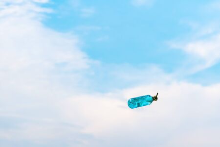 Antiseptic alcohol bottle floating on blue sky background, Campaign to prevent the spread of the Corona virus (Covid-19). New normal concept.の写真素材