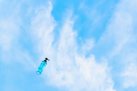 Antiseptic alcohol bottle floating on blue sky background, Campaign to prevent the spread of the Corona virus (Covid-19). New normal concept.の写真素材