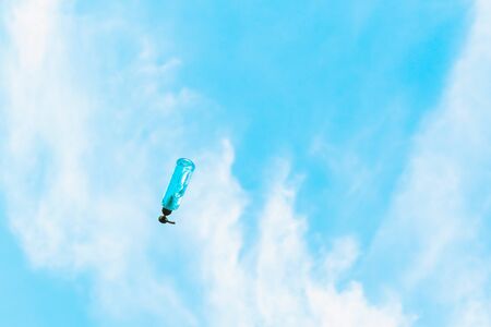 Antiseptic alcohol bottle floating on blue sky background, Campaign to prevent the spread of the Corona virus (Covid-19). New normal concept.の写真素材