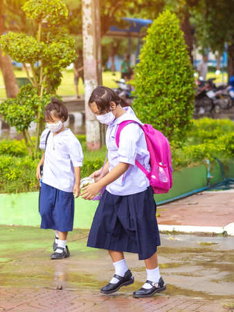 Kanchanaburi,Thailand-JULY 2,2020:Thai students wear various medical masks to prevent themselves from Coronavirus(Covid-19)in time after school and going back home after rain stopped at KTR school.のeditorial素材