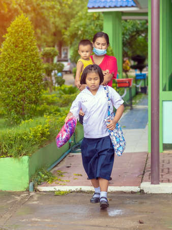 Kanchanaburi,Thailand-JULY 2,2020:Thai students wear various medical masks to prevent themselves from Coronavirus(Covid-19)in time after school and going back home after rain stopped at KTR school.のeditorial素材