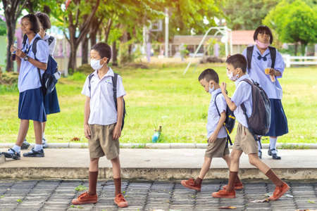 Kanchanaburi,Thailand-JULY 2,2020:Thai students wear various medical masks to prevent themselves from Coronavirus(Covid-19)in time after school and going back home after rain stopped at KTR school.のeditorial素材
