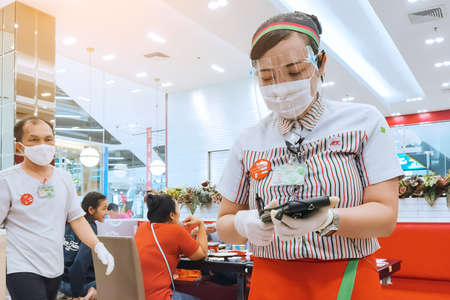Kanchanaburi, Thailand - June 21,2020: unidentified cashier and customers wear protective masks to protect against coronavirus (Covid-2019) and shopping at the Robinson Department Store.のeditorial素材