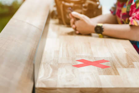 Female elementary school student wear face mask to prevent the Coronavirus(Covid-19) wait for her parents to pick her up to return home after school and the rain just stop in front of the school gateの写真素材