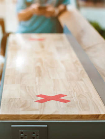 Female elementary school student wear face mask to prevent the Coronavirus(Covid-19) wait for her parents to pick her up to return home after school and the rain just stop in front of the school gateの写真素材