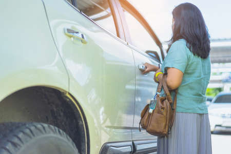 Mini portable alcohol gel bottle to kill Corona Virus(Covid-19) hang on a leather shoulder bag of a woman go to shopping at the department store. New normal lifestyle. Selective focus on alcohol gelの写真素材