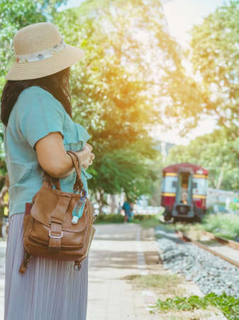 Mini portable alcohol gel bottle to kill Corona Virus(Covid-19) hang on a leather shoulder bag of a woman go to shopping at the mall. New normal lifestyle. Selective focus on alcohol gelの写真素材