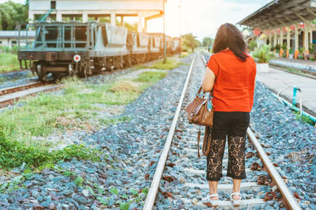 Mini portable alcohol gel bottle to kill Corona Virus(Covid-19) hang on leather shoulder bag of woman standing outdoor roadside.New normal lifestyle.Health care concept.Selective focus on alcohol gelの写真素材