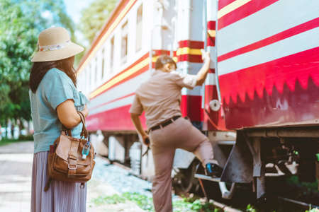 Mini portable alcohol gel bottle to kill Corona Virus(Covid-19) hang on a leather shoulder bag of a woman wearing a mask to travel in the city. New normal lifestyle. Selective focus on alcohol gelの写真素材