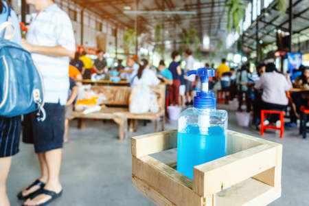 Blue alcohol gel bottle for hand cleaning to prevent the spreading of the Coronavirus (Covid-19), Placed on table to service for customers in the cafe. Healthcare concept. New normal lifestyleの写真素材