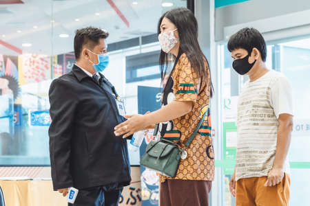KANCHANABURI, THAILAND-JULY 11,2020:Security guard use body thermometers and alcohol gel injection...