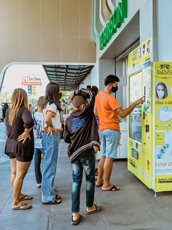 KANCHANABURI/THAILAND - AUGUST 9, 2020: Unidentified people choose to buy a fabric mask to prevent the Corona Virus (Covid-19) in vending machine in front of the entrance to Robinson Department Store.のeditorial素材