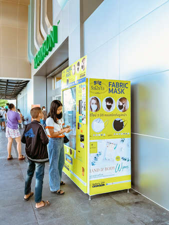 KANCHANABURI/THAILAND - AUGUST 9, 2020: Unidentified people choose to buy a fabric mask to prevent the Corona Virus (Covid-19) in vending machine in front of the entrance to Robinson Department Store.のeditorial素材