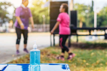 Blue alcohol gel bottle and a register book on the table for athletes to prevent Corona Virus (COVID...