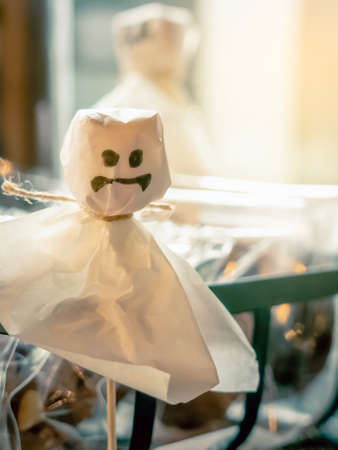 The white chocolate wrapping paper was painted with a black magic pen depicting a devil to grab the attention of customers during the Halloween season. Candy made into a figure of a ghost doll.の写真素材