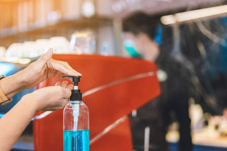 Female traveler wear surgical mask to prevent Corona Virus(COVID-19) using mobile phone to check the route while waiting for the van at transport station.New normal lifestyle, Selective focusの写真素材