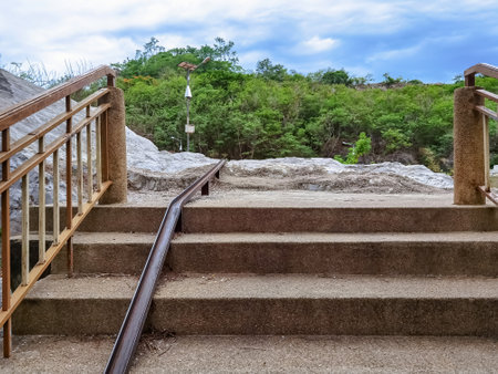 Stair-safe bike ramp along stairs. Comfortable and safe lanes for bicycles on stairs. Old and rusted steel rails for bicycles up and down for comfort between steps on stairs in the public park.の写真素材