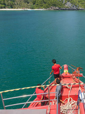 Top view of male crew prepared a rope to tie a buoy at bow of the ship before mooring at the shore...