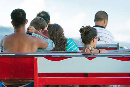 Back view of female passengers relaxing on balcony enjoying view from boat of Samui island in the...