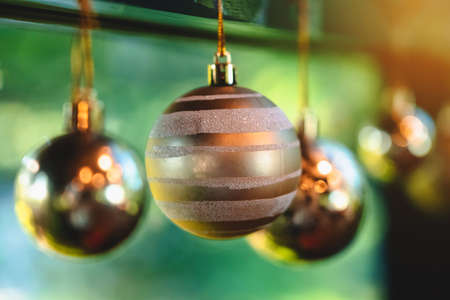 Golden glitter Christmas balls hanging for decorations on background window.Stylish christmas...