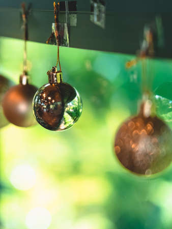Golden glitter Christmas balls hanging for decorations on background window.Stylish christmas decoration.Christmas and New Year display for celebration,carnival,festival design concept.Selective focusの写真素材