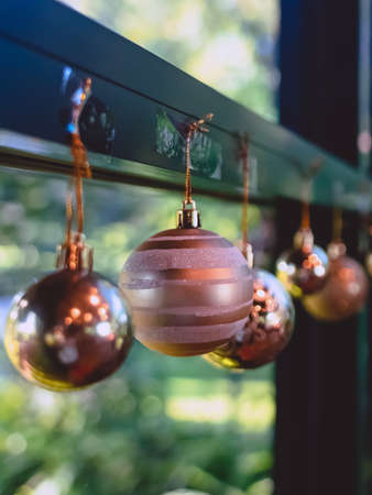 Golden glitter Christmas balls hanging for decorations on background window.Stylish christmas decoration.Christmas and New Year display for celebration,carnival,festival design concept.Selective focusの写真素材