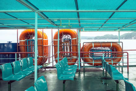 Orange inflatable lifeboats on ferry deck for emergencies and maritime accidents. Rescue boat, raft on the roof of a ferry.  Life boats on big ship on ocean sea cruise ship.Transportation and safety.の写真素材