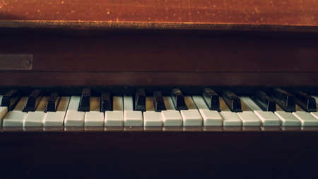 Close up shot to broken piano keys in abandoned house. An ancient musical instrument. Old broken disused piano with damaged keys Vintage Retro Filter. Distressed Piano made of wood. Selective Focus.の写真素材