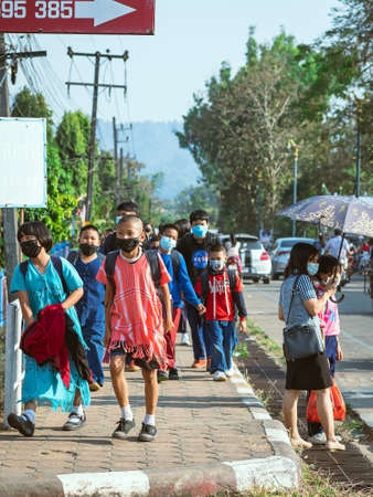 KANCHANABURI, THAILAND-JANUARY 14,2022 : Students of five different nationalities (Thai, Lao, Mon, Karen and Burmese) wear face masks to prevent Corona virus (COVID-19) on the way home after school.のeditorial素材