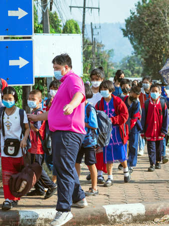 KANCHANABURI, THAILAND-JANUARY 14,2022 : Students of five different nationalities (Thai, Lao, Mon, Karen and Burmese) wear face masks to prevent Corona virus (COVID-19) on the way home after school.のeditorial素材