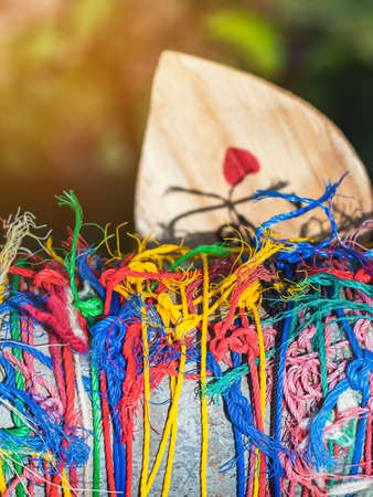 Many suspended chaotically intertwined colorful ropes tied into messy knots for plate wood hanging...