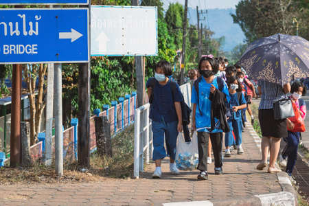 KANCHANABURI, THAILAND-JANUARY 14,2022 : Students of five different nationalities (Thai, Lao, Mon, Karen and Burmese) wear face masks to prevent Corona virus (COVID-19) on the way home after school.のeditorial素材