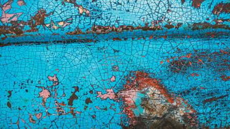 Enamelled colorful cracked and peeling surface of old motorcycle. Rusty metal surface with blue cracked paint. Old motorbike paint cracks and rust. Rusty old metal. Vintage textured background conceptの写真素材
