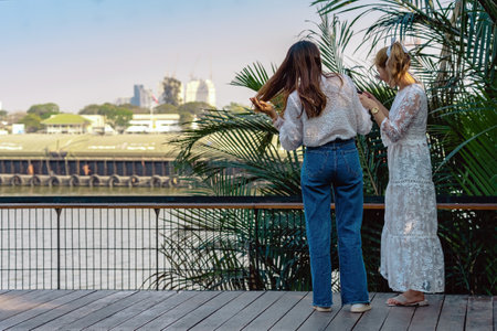Back view portrait of attractive Asian women traveler take photo by digital camera together at...