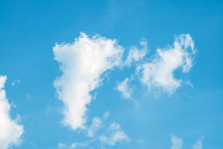 Clouds in the blue sky. Natural sky background texture, beautiful color. Peaceful blue sky with light clouds. The free form beauty of clouds and sky is perfect for background, backdrop and wallpaper.の写真素材