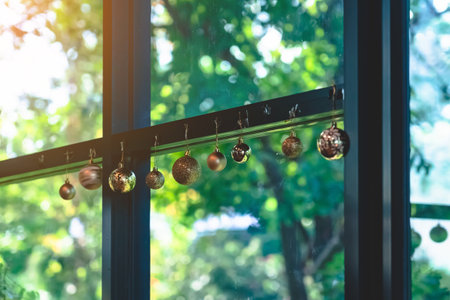 Golden glitter Christmas balls hanging for decorations on background window.Stylish christmas decoration.Christmas and New Year display for celebration,carnival,festival design concept.Selective focusの写真素材