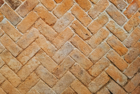 Top view of old bricks paving stones footpath pattern on sidewalk outdoors as brickwork weave texture or abstract stone paver herringbone template background. Top view of pavement surface.の写真素材