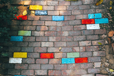 Top view of old beautiful multicolor bricks paving stones footpath pattern on sidewalk outdoors as brickwork weave texture or abstract stone paver background. Pavement Surface. Background and texture.の写真素材