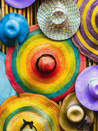 Variety of fashionable and colorful hats hanging on bamboo backdrop of curbside shop. Tourism designer straw hats from the sun of different colors. Design of tourist beach hats. Beach hats for summer.の写真素材